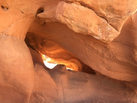 Light falling through a narrow orange sandstone canyon
